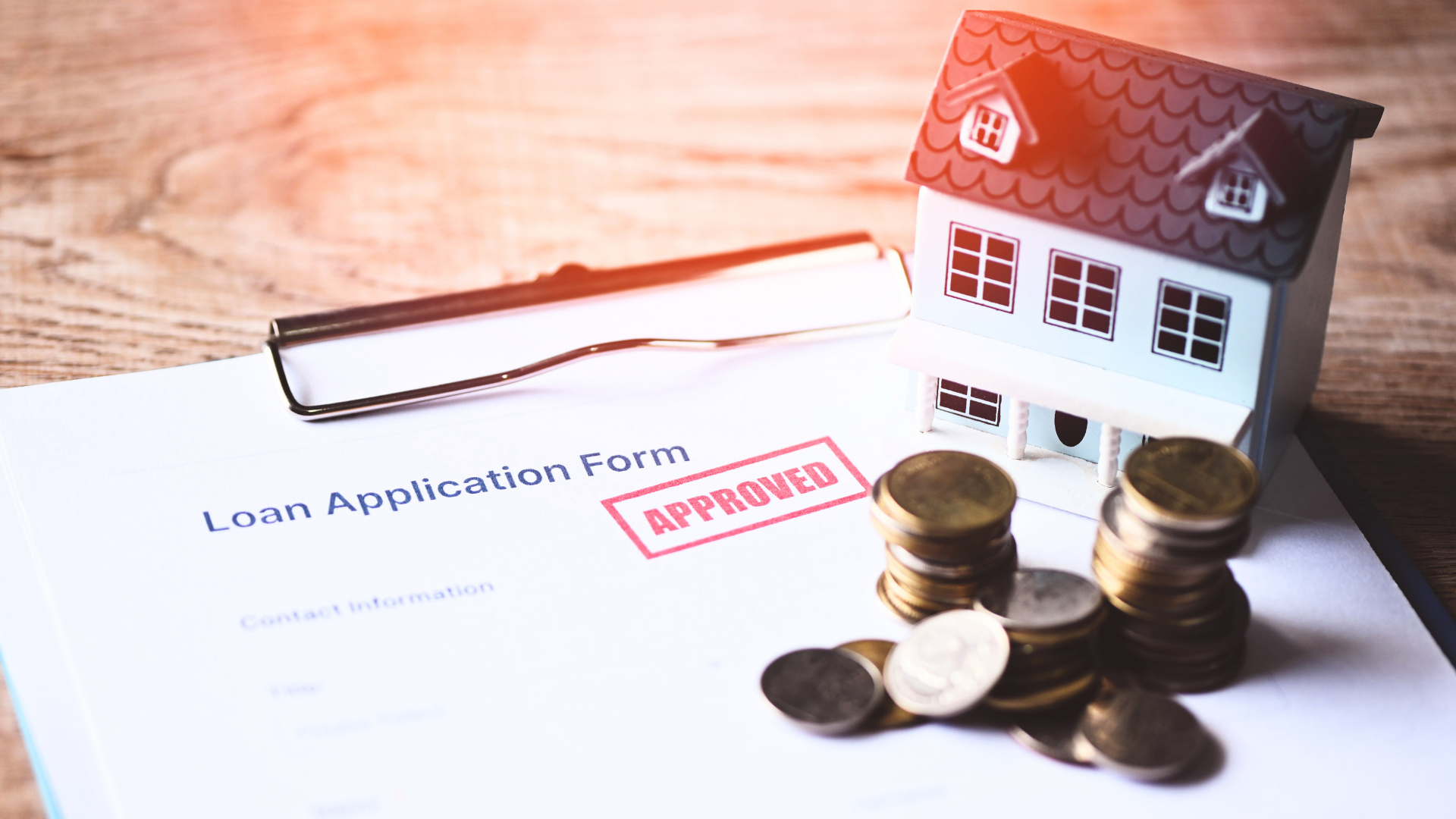 Encumbered Property - Loan Application Form with Approved Stamp, Coins and House Model